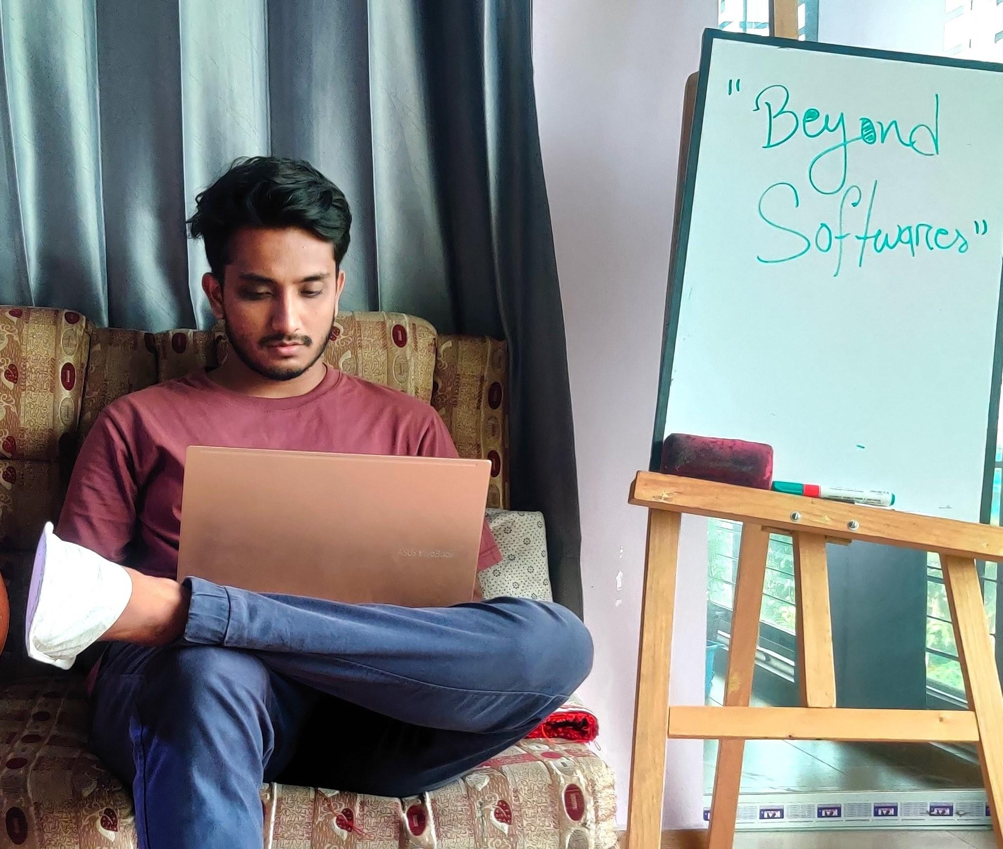 Aehtesham working on his laptop at home
